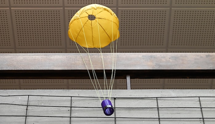 Ein Fallschirm bremst den Absturz des Dosensatelliten auf die Erde