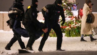 Polizisten nehmen in St. Petersburg einen Mann fest, der für Nawalny Blumen niederlegte. (Bild: AP)