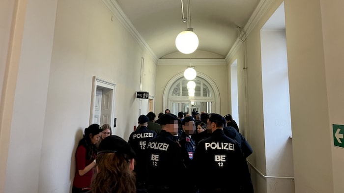 Police push the outraged crowd towards the court exit.