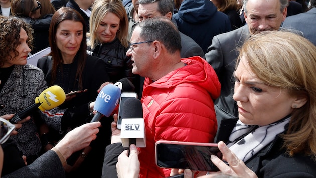 Janitor Julian - besieged by journalists in his red jacket - is the hero of Valencia. (Bild: APA/AFP/JOSE JORDAN)