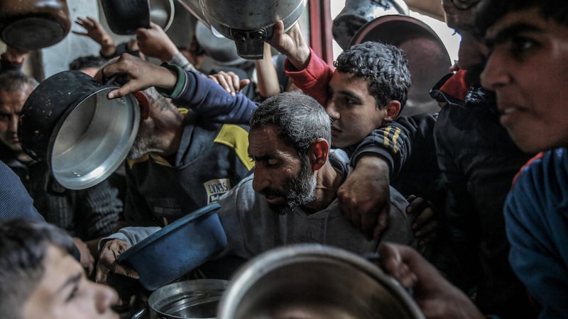 Starving Palestinians at food distribution point (Bild: AFP)