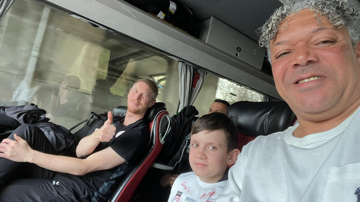 Maxi Pulko durfte im Mannschaftsbus der Rothosen mit Trainer Roman Ellensohn (li.) und Sportdirektor Eric Orie auf den Chefplätzen sitzen. (Bild: FC Dornbirn)