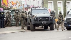 Polizisten bei einem gepanzerten Fahrzeug am Sonntag. Der Einsatz stand im Zusammenhang mit der Fahndung nach den beiden noch flüchtigen mutmaßlichen RAF-Räubern. (Bild: APA/dpa/Paul Zinken)