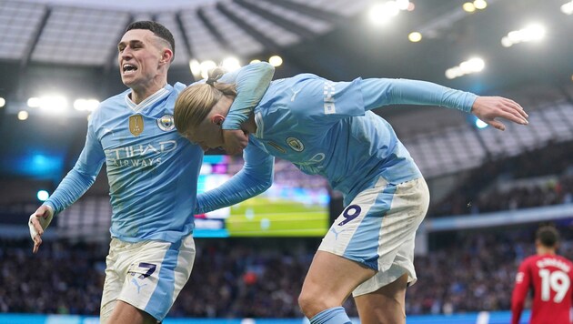 Phil Foden (left) and Erling Haaland celebrate the derby win