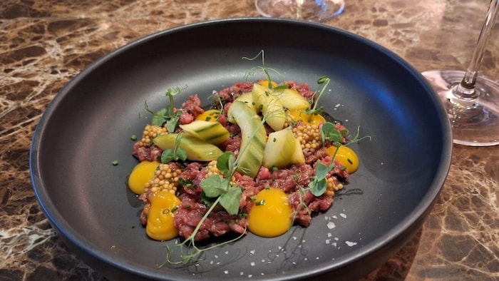 Beef Tartare mit Dottercreme, Melone und frischen Kräutern. Serviert wird dazu noch ein frisches ...