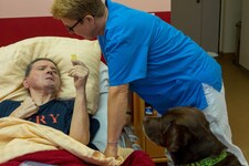 Doris Karasek mit Abby am Bett von Rudi. Er kann nach einer Gehirnblutung kaum mehr kommunizieren, durch den Hund bemüht er sich aber Worte zu formulieren. (Bild: Charlotte Titz)