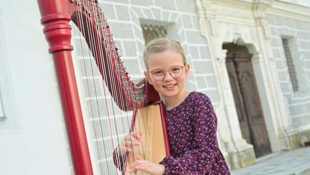 Die kleinste Harfinistin: Johanna Sacherer ist sieben Jahre alt. Sie kommt aus Althofen. Sie holte einen 1. Preis mit Auszeichnung ab. Der Papa kriegt nun fürs Harfe tragen viele bunte Smarties. (Bild: EVELYN HRONEK)