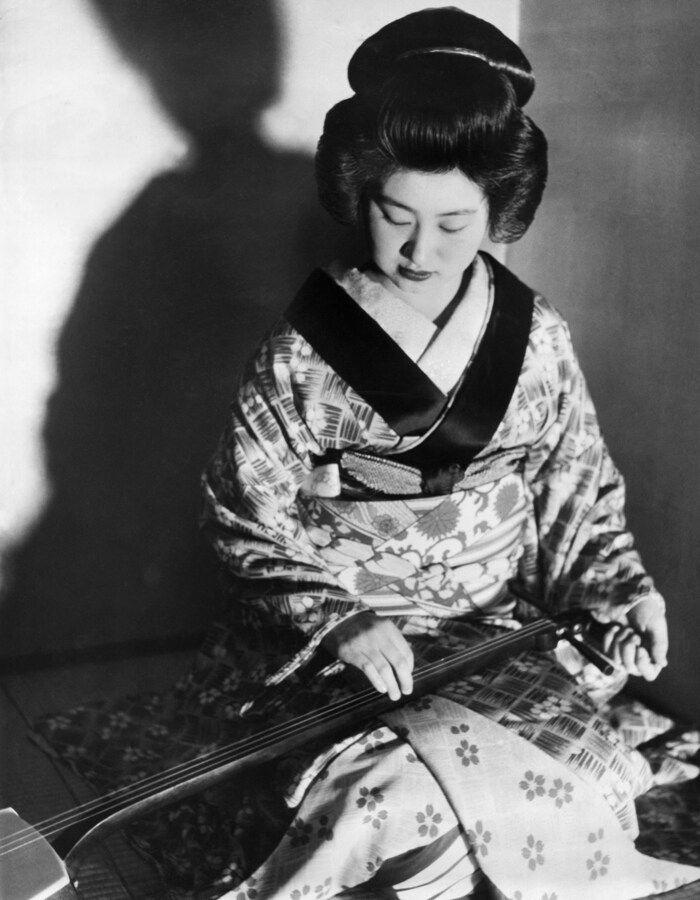 Eine Geisha spielt 1939 in Tokio auf einem Instrument, das Samisen genannt wird.