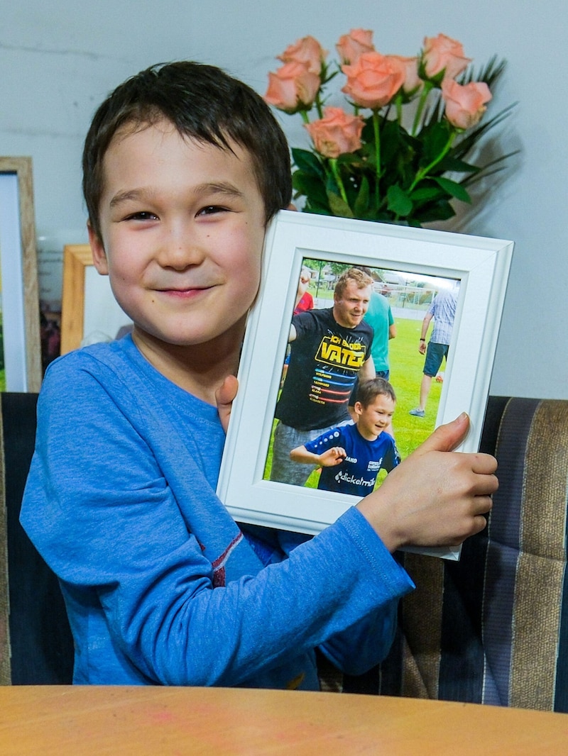 Sohn Leonhard (8) mit einem Foto, das ihn mit Papa Markus beim Fußballtraining zeigt (Bild: Horst Einöder/Flashpictures)