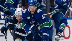 Teddy Blueger von den Vancouver Canucks (re.) im Duell mit Josh Morrissey von den Winnipeg Jets (Bild: AP)