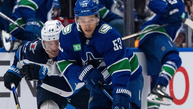 Teddy Blueger von den Vancouver Canucks (re.) im Duell mit Josh Morrissey von den Winnipeg Jets (Bild: AP)