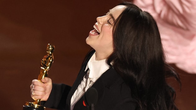 Sängerin Billie Eilish jubelt über ihren Oscar für den Originalsong „What Was I Made For?" (Bild: Mike Blake / REUTERS / picturedesk.com)