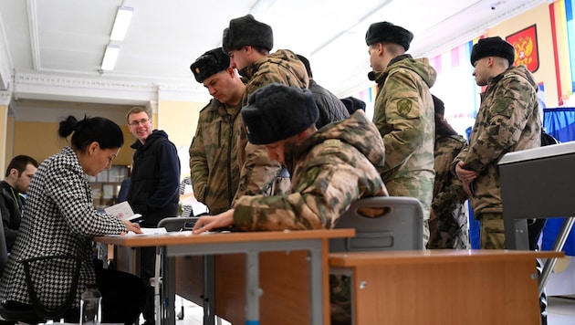 Des militaires à Moscou s'inscrivent pour participer à l'élection présidentielle russe. (Bild: APA/AFP/NATALIA KOLESNIKOVA)