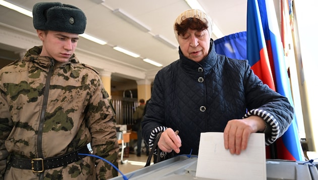 Une femme à Moscou lors du dépôt de son bulletin de vote. (Bild: APA/AFP/NATALIA KOLESNIKOVA)