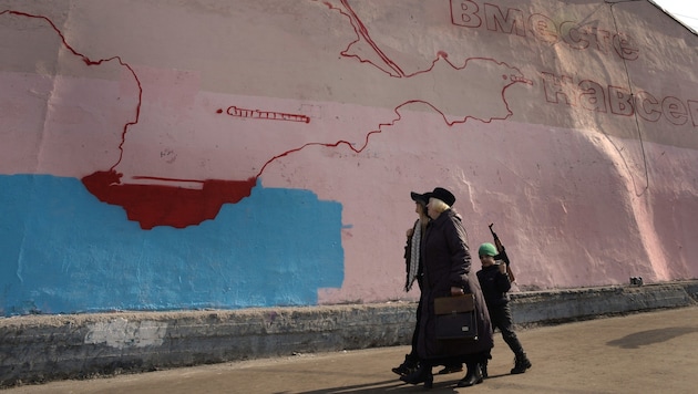 "Por siempre unidos" está escrito en un mural de Crimea en Moscú (imagen de archivo de marzo de 2014). Ucrania quiere recuperar la península que le fue robada hace diez años. (Bild: APA/AFP/Alexander NEMENOV)