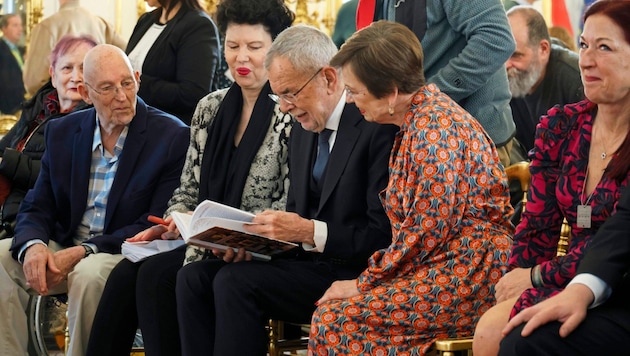 Federal President Alexander Van der Bellen, his wife Doris Schmidauer (right) and Susanne Trauneck from the Jewish Welcome Service show great interest in the autobiography of Carlos Burger (left), whose parents had to flee from the Nazis. (Bild: Reinhard Holl)
