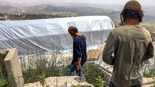 Colonos israelíes en el "puesto avanzado" de Homesch, en Cisjordania. (Bild: APA/AFP/Menahem KAHANA)