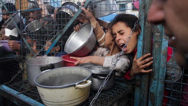 Ausgehungerte Palästinenser stehen im Flüchtlingslager Jabaliya im Gazastreifen Schlange, um kostenlose Mahlzeiten zu erhalten. (Bild: ASSOCIATED PRESS)