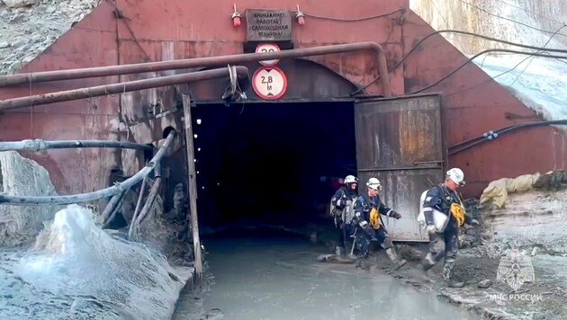 Trabajadores de la defensa civil rusa frente a la entrada de la mina de oro derrumbada en la región de Amur. (Bild: Russia Emergency Situations Ministry Press Service via AP)