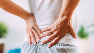Heftige Schmerzen, die bis in die Beine ausstrahlen können, sind typische Anzeichen. (Bild: Microgen – stock.adobe.com / KroneMED)