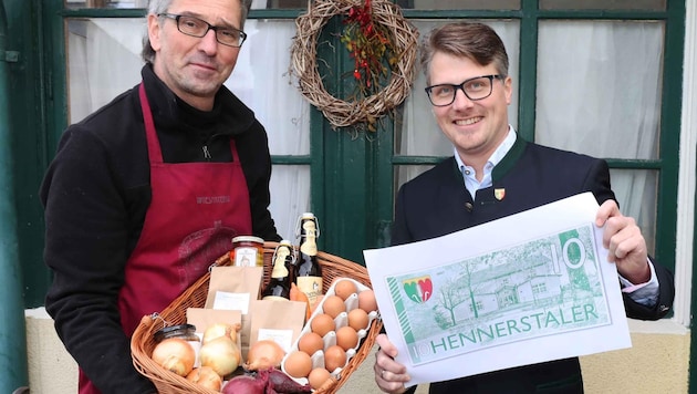 Bürgermeister Thaddäus Heindl (re.) und Hanns Wiesmayer präsentieren die eigene Ortswährung von Hennersdorf – den „Hennerstaler“. (Bild: Judt Reinhard)