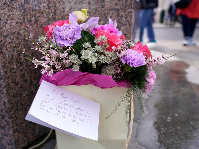 Menschen hinterlassen vor Schloss Windsor Blumen und Genesungswünsche für Prinzessin Kate. (Bild: APA/AP Photo/Alberto Pezzali)