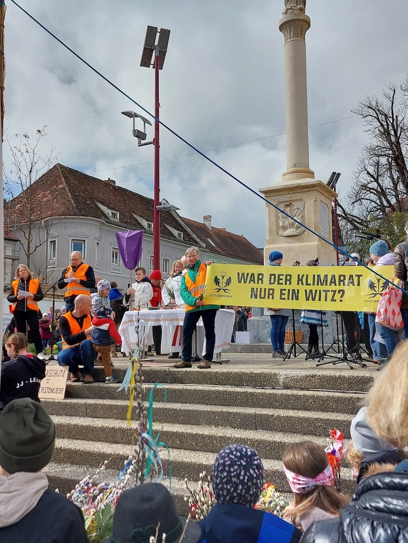 Mit Warnwesten und Transparenten tauchten Aktivisten bei der Palmweihe in Weiz auf. (Bild: Letzte Generation Österreich)