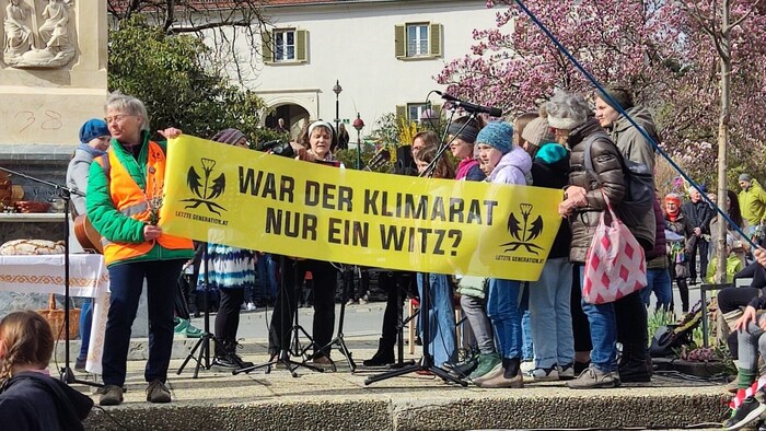 Klimaaktivisten nutzten die Palmweihe in Weiz als Bühne für ihre Anliegen.