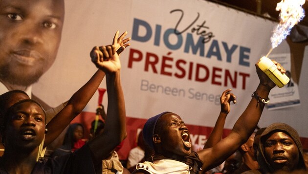 Anhänger der Opposition jubeln in Dakar über den deutlichen Wahlsieg. (Bild: APA/AFP/MARCO LONGARI)
