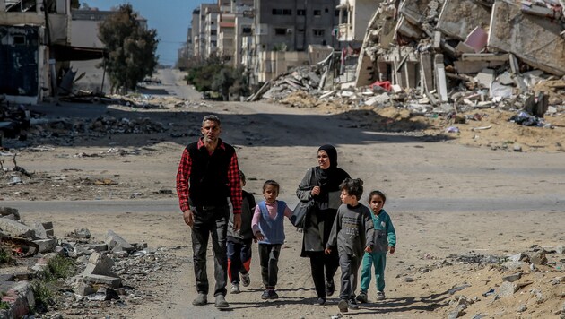 Egy család a szinte teljesen elpusztított Gázai övezetben. (Bild: AFP)