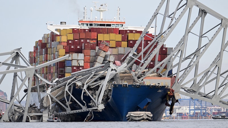 Das riesige Containerschiff verkeilte sich in die Brückenkonstruktion. (Bild: APA/AFP/Jim WATSON)