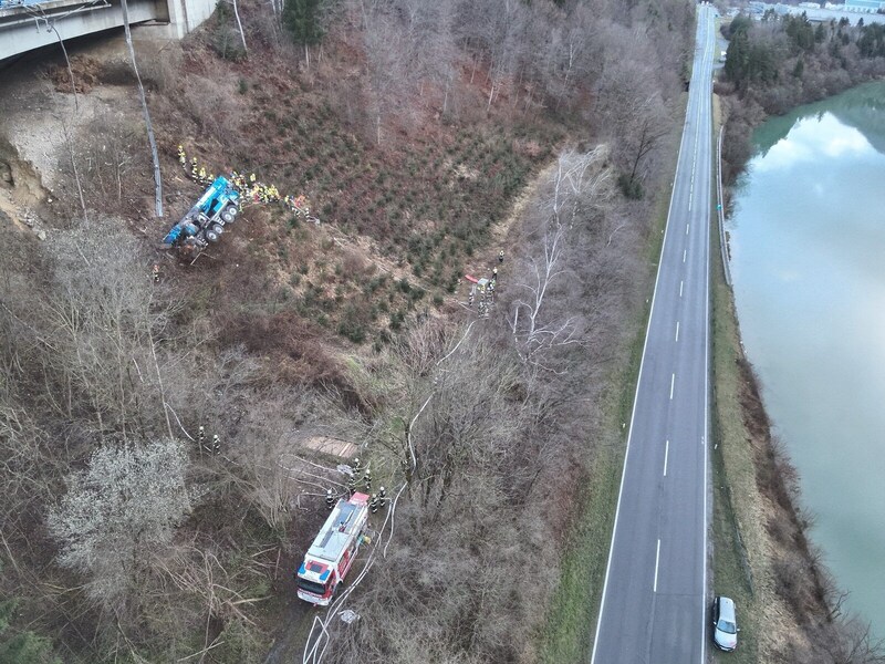 Links im Bild die Autobahnbrücke, am Hang der abgestürzte Lkw, rechts die Bundesstraße. feuerwehr-villach.at (Bild: feuerwehr-villach.at)