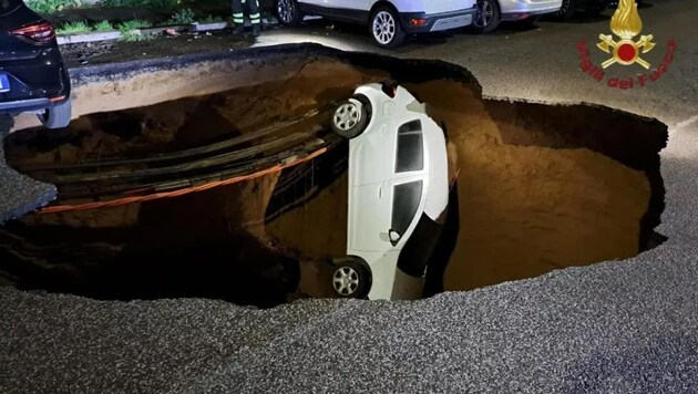 Two cars plunged into the pit - a third was narrowly spared. (Bild: Vigili del Fuoco)