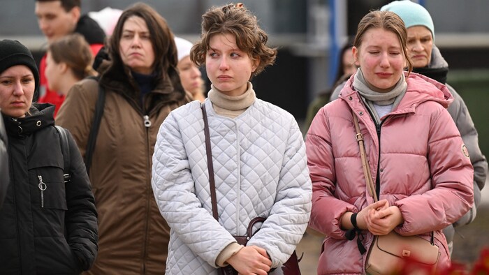 Junge Frauen weinen vor der Crocus City Hall.
