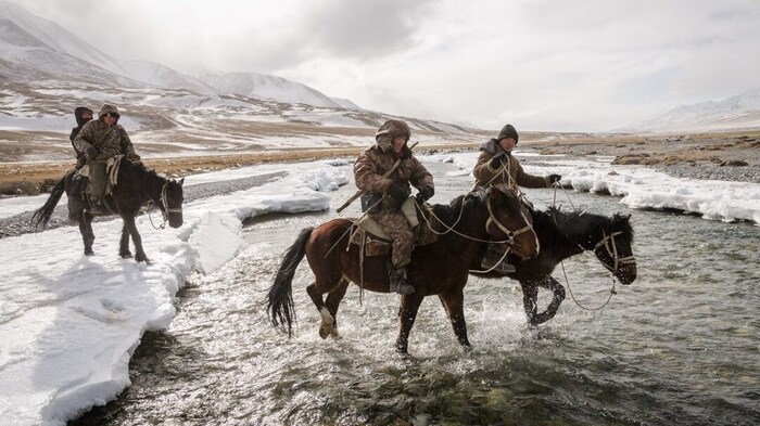 On his return from an unsuccessful wolf hunt, he crosses a small branch of the Great Naryn River in late winter. 