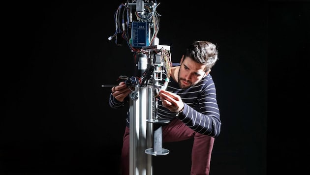 Sébastien Le Fouest mit seiner motorisierten und mit Sensoren ausgestatteten Miniaturwindkraftanlage mit vertikaler Rotationsachse. (Bild: Alain Herzog / EPFL)