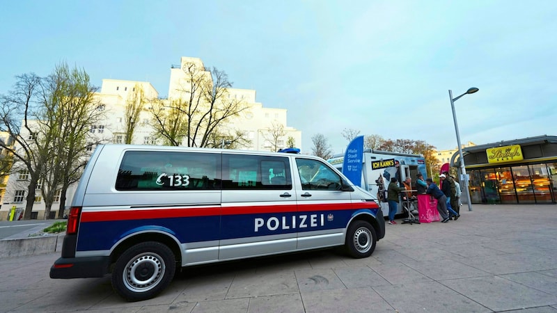 Die Polizei und mehrere Dienststellen der Stadt zeigen am Brennpunkt Reumannplatz – im Hintergrund das Amalienbad – seit mehreren Tagen eine verstärkte Präsenz. (Bild: EVA MANHART / APA / picturedesk.com)