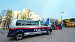 Die Polizei und mehrere Dienststellen der Stadt zeigen am Brennpunkt Reumannplatz – im Hintergrund das Amalienbad – seit mehreren Tagen eine verstärkte Präsenz. (Bild: EVA MANHART / APA / picturedesk.com)