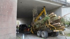 Der Kran auf dem Holztransporter war nicht ganz eingezogen, weshalb das Gespann unter der A8 stecken blieb. Feuerwehr, Polizei und Rettung waren im Einsatz. (Bild: FF Meggenhofen)