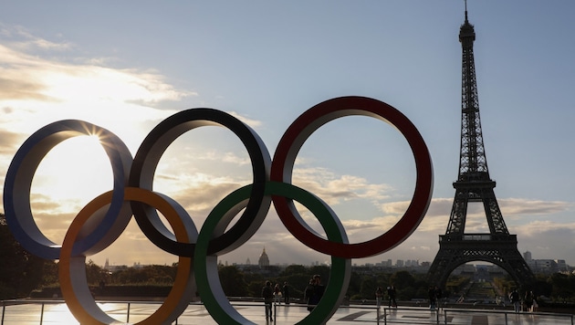 Olympische Ringe werden am Eiffelturm angebracht. (Bild: APA/AFP/LUDOVIC MARIN)