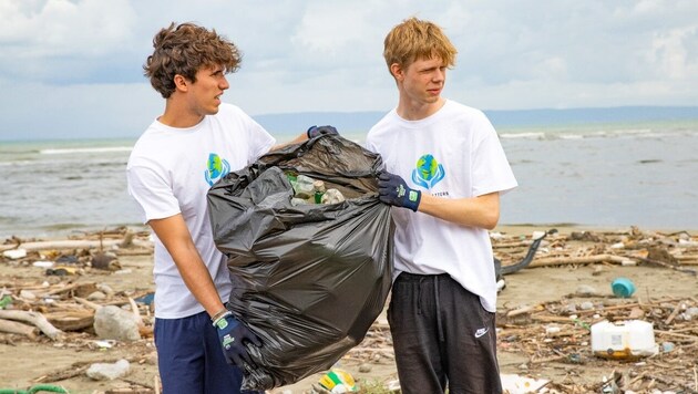 Felix Krainer (li) beim Müllsammeln am Strand – er inspiriert damit Tausende! (Bild: Planet Matters)