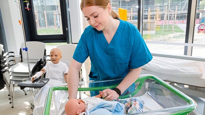 Student Michaela learns the first moves on medical mannequins in the training room.
