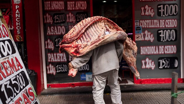 Egy férfi húst szállít az argentin fővárosban. (Bild: AP)