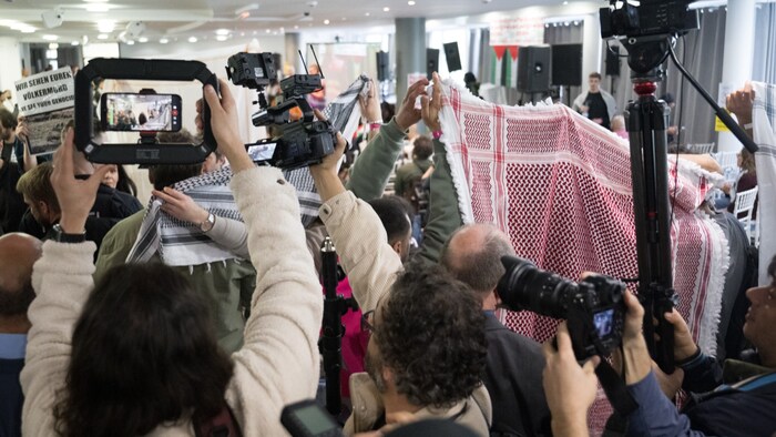  Teilnehmer versuchten vor Beginn des Palästina-Kongress 2024 Journalisten am Filmen und Fotografieren zu hindern, in dem sie Kufiyas und Tücher hochhielten. 