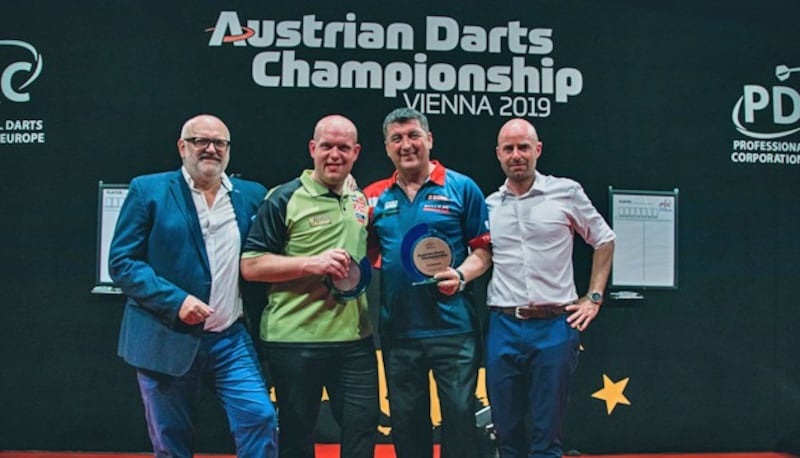 Ein Bild aus besseren Tagen: Suljovic (2. v. re.) nach seinem Finaltriumph gegen Michael van Gerwen (2. v. li.) in Schwechat 2019. Ganz links: Manager Alfred Söls. Ganz rechts: Sebastian Mayer, damals PDC Europe (Bild: www.chaluk.com)