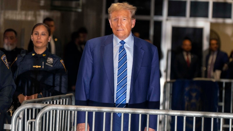 Trump hinter „Gittern“ – hier spricht er nach dem zweiten Prozesstag zu einem Journalisten, wirkt dabei wie eine Statue. (Bild: Mark Peterson-Pool/Getty Images/AFP POOL / GETTY IMAGES NORTH AMERICA / Getty Images via AFP)