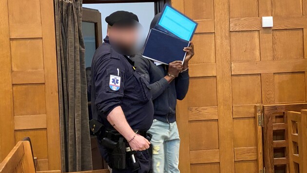 When the African man saw the media representatives with their cameras in the courtroom, he sobbed: "Please don't!" and hid his face behind a folder. (Bild: Chantall Dorn, Krone KREATIV)