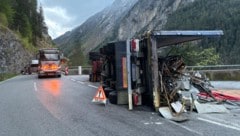 Der umgestürzte Lastwagen – eine Begrenzungsmauer verhinderte einen weiteren Absturz. (Bild: zoom.tirol, Krone KREATIV)