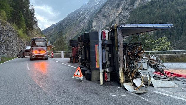 Der umgestürzte Lastwagen – eine Begrenzungsmauer verhinderte einen weiteren Absturz. (Bild: zoom.tirol, Krone KREATIV)