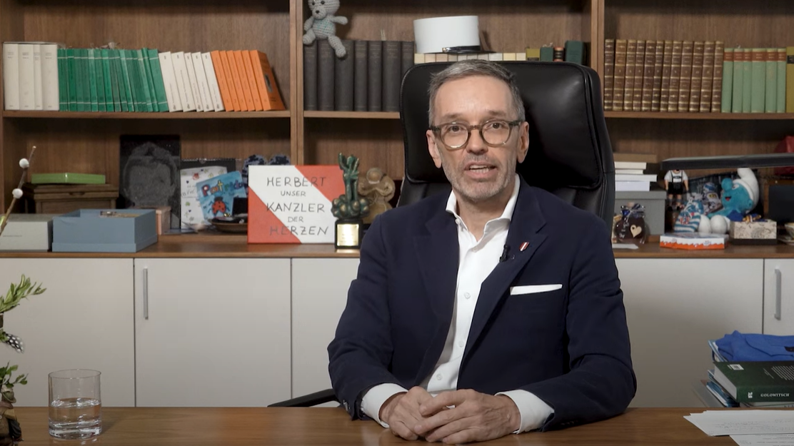 Kickl presented himself in his office, surrounded by gifts such as a smurf, children's chocolate and a teddy bear. (Bild: Screenshot/YouTube/FPÖ TV)